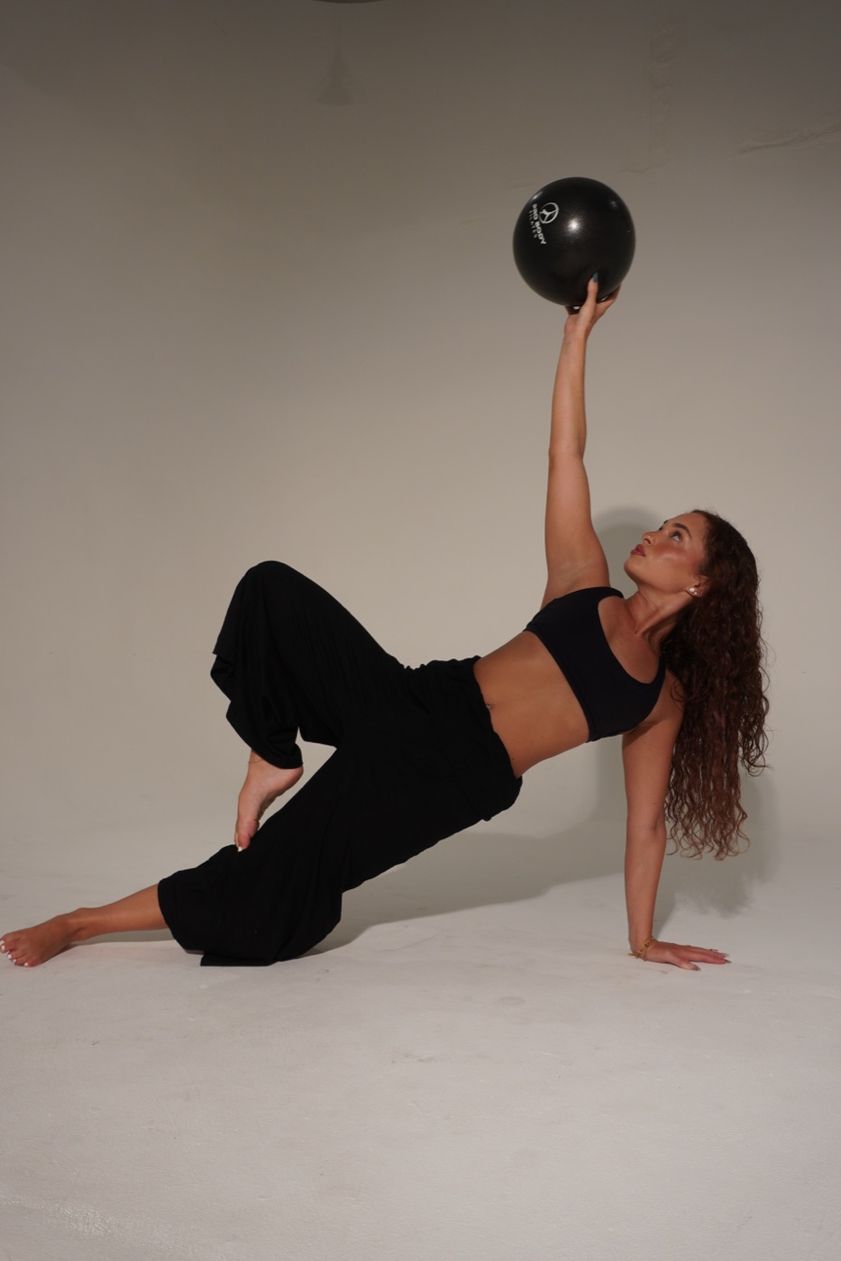 Olivia mid-movement, reaching upward in a side plank